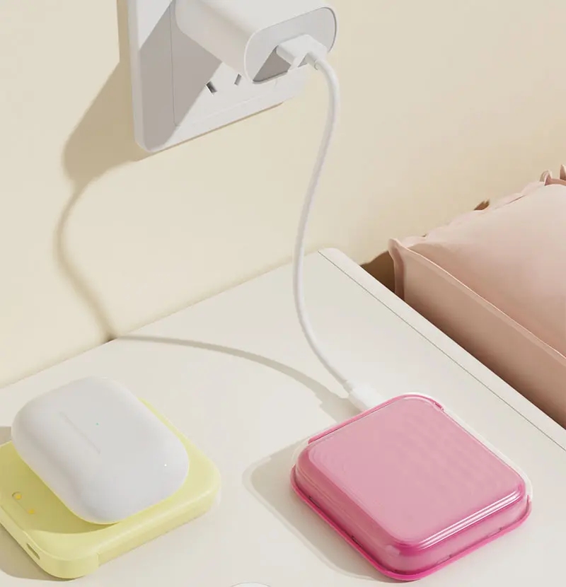 Pink and yellow AJ04 magnetic wireless power banks connected to a charger