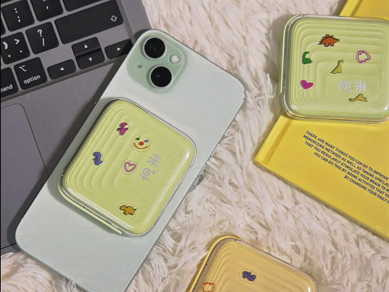 Yellow AJ04 magnetic wireless power bank attached to a light green phone