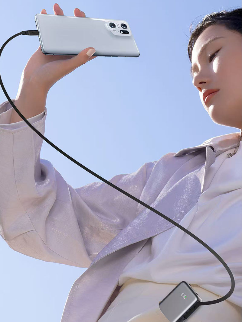 Person holding a phone connected to an AJ07 power bank cable