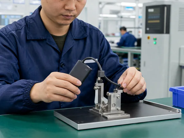 Chinese quality control technician testing built-in cable durability