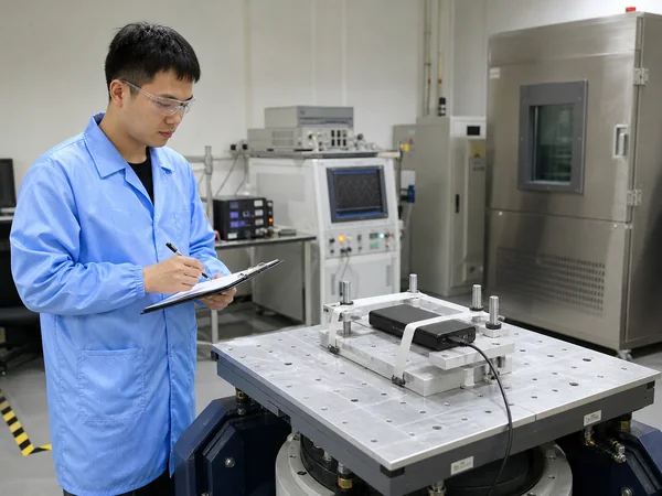 Chinese laboratory technician testing a power bank on vibration equipment for UN 38.3