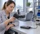 Female quality engineer using an infrared camera to inspect a power bank on a thermal test bench