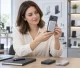 Buyer inspecting a magnetic power bank attached to a smartphone in a product review showroom